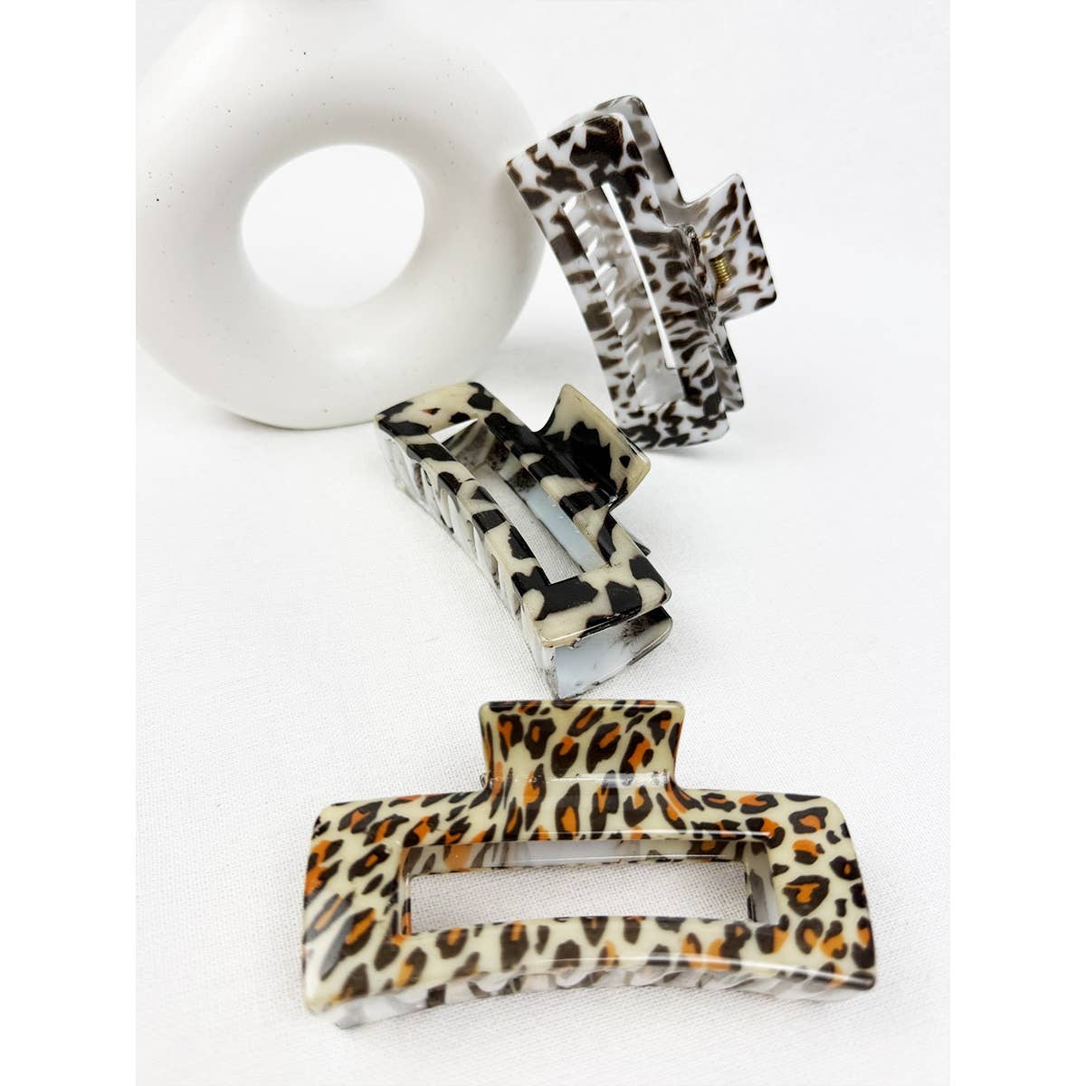 Set of three leopard print hair clips on a white background